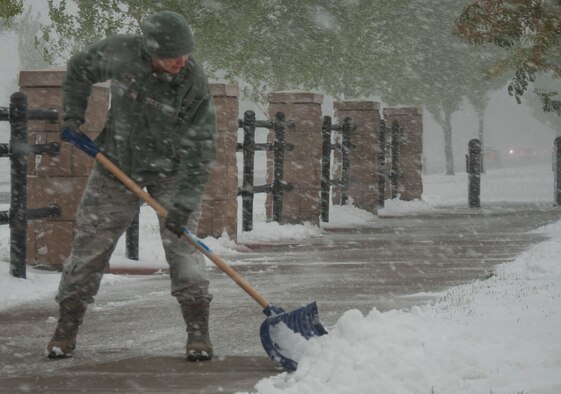 131004-F-CP692-023 F.E. Warren Air Force Base, Wyo., saw its first snow storm of the season Oct. 4, 2013. Airmen across the base donned their snow gear and fought back to continue their mission. Staff Sgt. Jennifer Dowling, 90th Missile Wing executive assistant to the command chief, shoveled snow off the sidewalks leading into the wing headquarters to prevent build up and create easier access to the building. If the base commander deems it necessary for either base personnel todelay reporting or for the base to be closed, the 90th Missile Wing Public Affairs Office will make updates after 5:30 a.m. to the Straight Talk Line at 307-773-2222, the base Facebook site at www.facebook.com/warrenAFB, and provide local media outlets with information. U.S. Air Force photo by 1st Lt. Eydie Sakura)