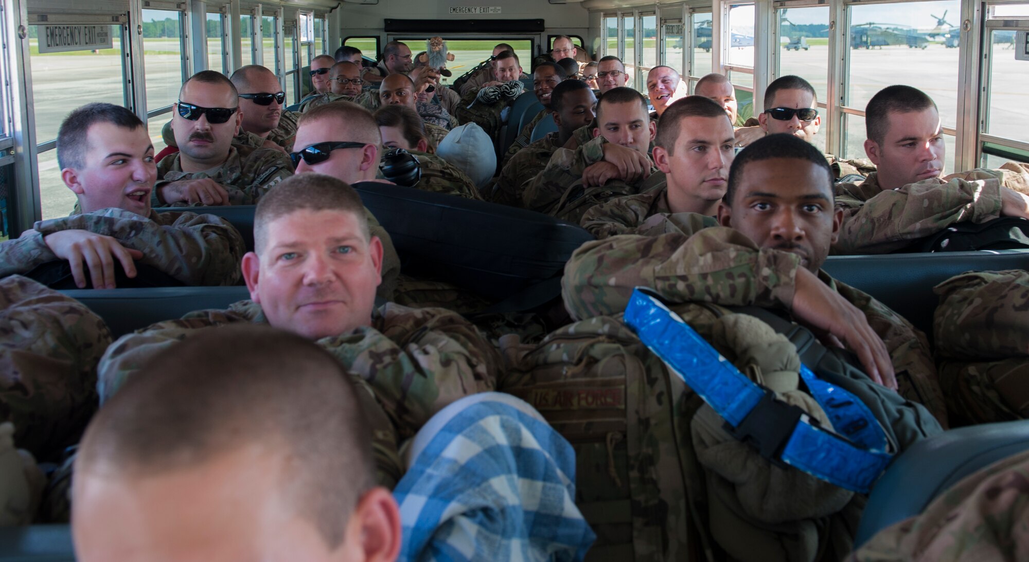 Airmen sit on buses and wait to board an aircraft for deployment at Moody Air Force Base, Ga., Sept. 27, 2013. A total of 285 Airmen deployed to Southwest Asia from Moody. (U.S. Air Force photo by Airman Alexis Grotz/Released)