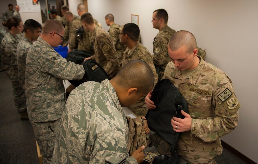 Airmen line up for a routine baggage check before boarding a plane for deployment at Moody Air Force Base, Ga., Sept. 27, 2013. The baggage check ensures Airmen have what they need and have not exceeded the amount of items in their carry-on bags. (U.S. Air Force photo by Airman Alexis Grotz/Released)