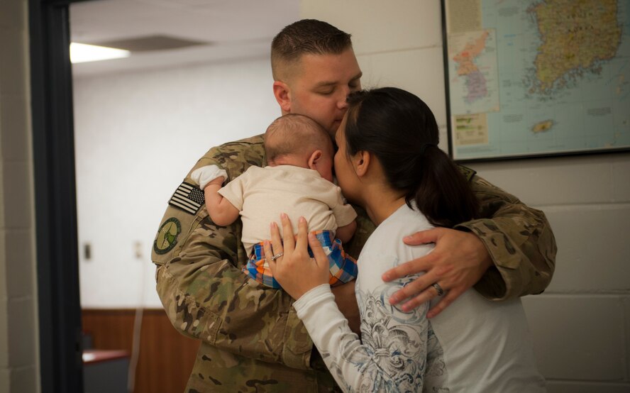 U.S. Air Force Staff Sgt. Gregory Chick, 23d Equipment Maintenance Squadron aerospace ground equipment journeyman, hugs his wife and son at Moody Air Force Base, Ga., Sept. 27, 2013. Chick was one of 285 Airmen to leave for deployment. (U.S. Air Force photo by Airman Alexis Grotz/Released)