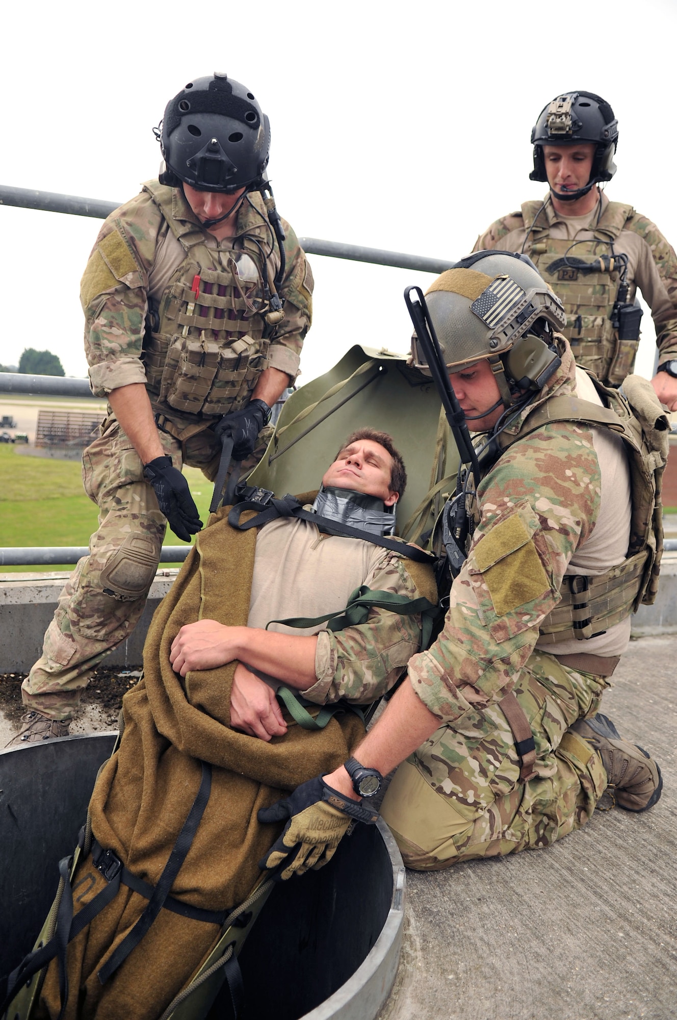U.S. Air Force pararescuemen from the 321st Special Tactics Squadron pull a “wounded” patient to safety Oct. 2, 2013, on RAF Mildenhall, England. Pararescuemen trained on how to successfully negotiate an extraction of “wounded” personnel as part of a confined-space extraction exercise. Airmen from the 321st STS routinely train on different scenarios in order to stay certified and prepared to execute any mission necessary. (U.S. Air Force photo by Airman 1st Class Kyla Gifford/Released)