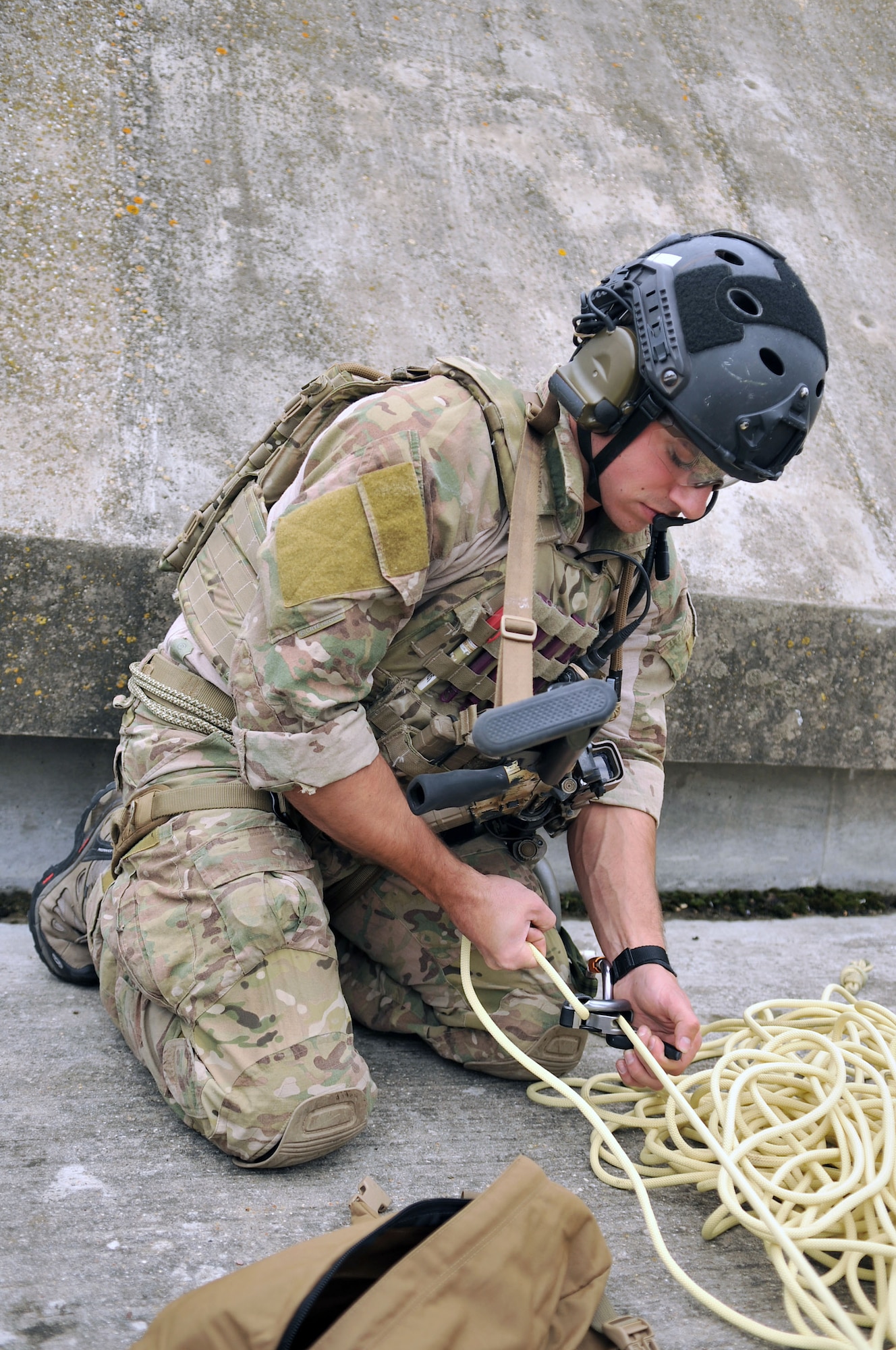 U.S. Air Force Staff Sgt. Trevor Clark, 321st Special Tactics Squadron pararescueman, feeds rope through a belaying device Oct. 2, 2013, on RAF Mildenhall, England. Clark assisted in the recovery of simulated wounded personnel during the confined-space extraction exercise. Airmen from the 321st STS routinely train on different scenarios in order to stay certified and prepared to execute any mission necessary.  (U.S. Air Force photo by Airman 1st Class Kyla Gifford/Released)