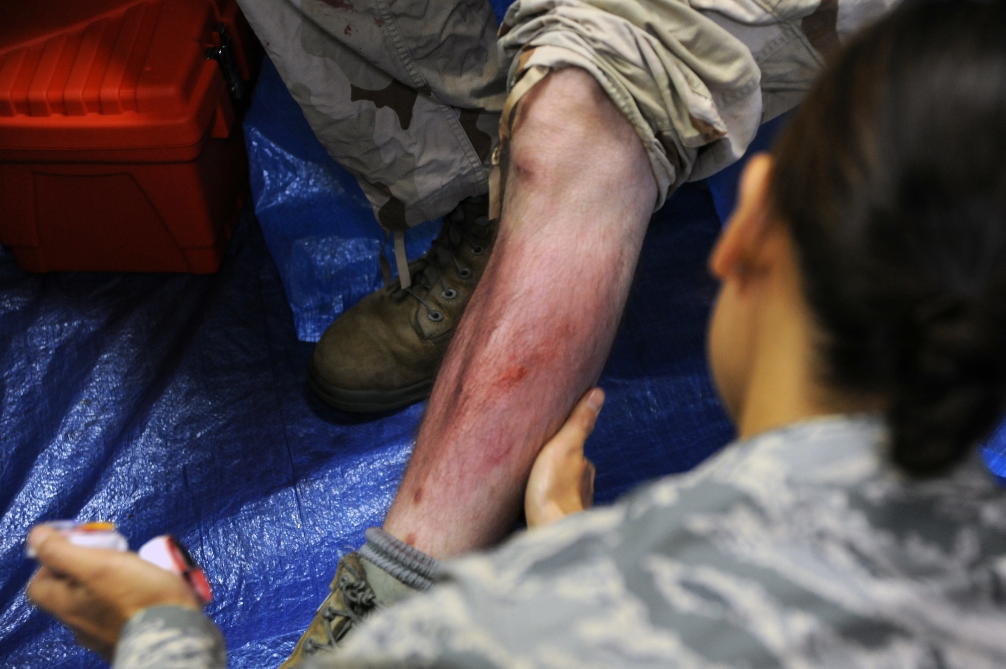 Tech. Sgt. Anabel Parks, 35th Dental Squadron, applies a moulage injury to Senior Airman Paul Takita, 35th Comptroller Squadron, during an Operational Readiness Exercise at Misawa Air Base, Japan, Oct. 7, 2013. Parks applied artistic injuries to all role players during the week-long exercise using props, makeup and fake blood in an effort to test the Self-Aid Buddy Care skills of first-responders. (U. S. Air Force photo by Senior Airman Derek VanHorn)