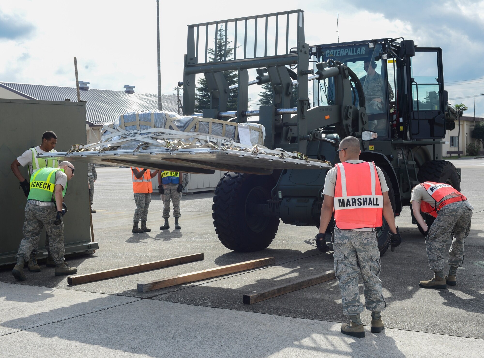 Airmen check the clearance of a pallet as it’s being lowered onto 4x4s during a simulated deployment preparation at Yokota Air Base, Japan, Oct. 7, 2013. As Airmen checked the weight and size of the cargo, they were being graded on their performance. (U.S. Air Force photo by Senior Airman Michael Washburn/Released)