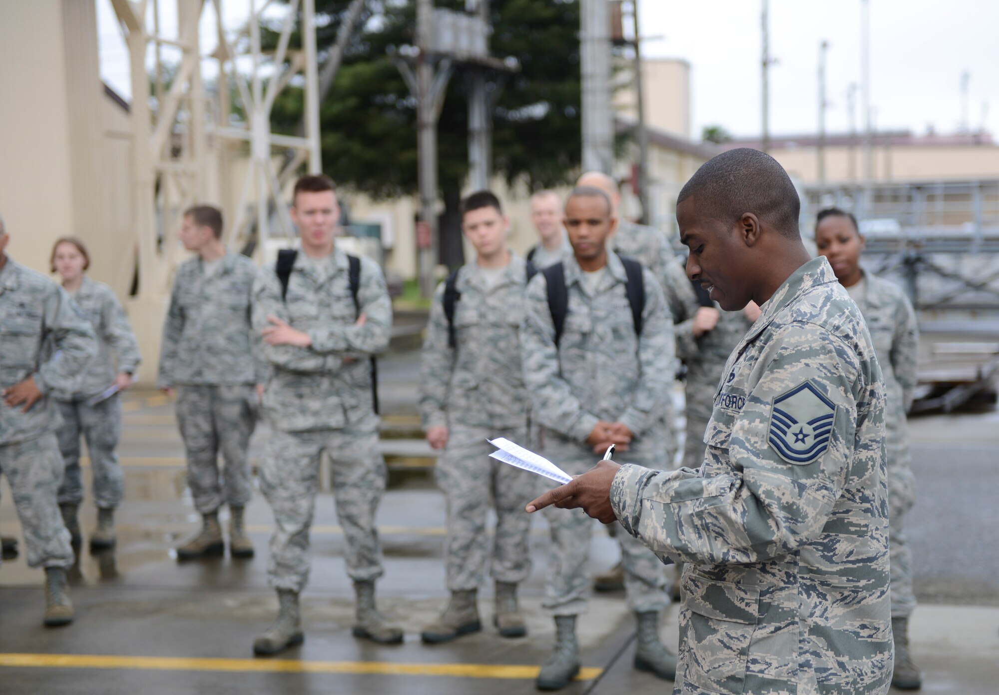 Master Sgt. Shawn Simien, 374th Logistics Readiness Squadron, assigns roles and briefs participants before a simulated deployment preparation on the flightline at Yokota Air Base, Japan, Oct. 7, 2013. The group of Airmen were split into both day and night shifts to accommodate 24-hour operations. (U.S. Air Force photo by Senior Airman Michael Washburn/Released)