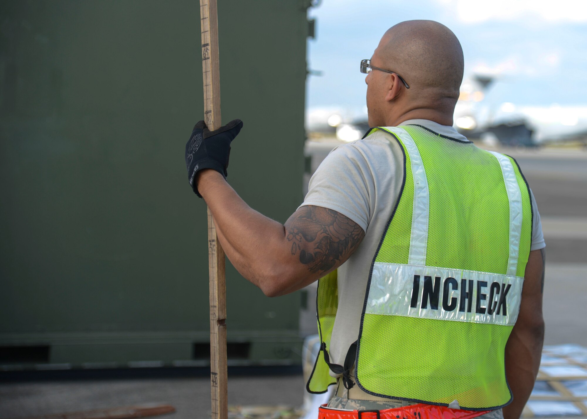 An Airman waits for cargo delivery which he will measure with a pre-marked measuring stick as part of a simulated deployment process at Yokota Air Base, Japan, Oct. 7, 2013.  Several pieces of cargo were transported, weighed and measured during the simulated deployment preparation.  (U.S. Air Force photo by Airman 1st Class Soo C. Kim/released)