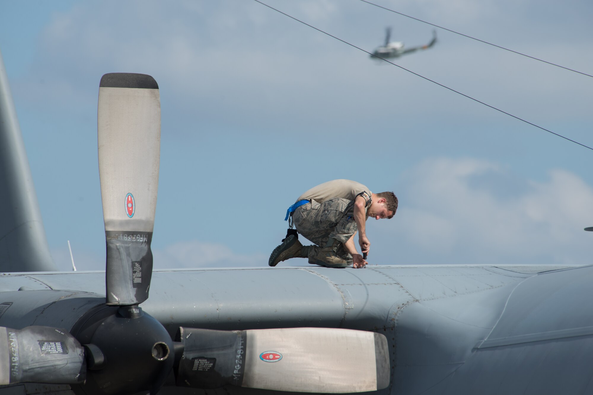 Airman 1st Class David Saraj, 374th Aircraft Maintenance Squadron crew chief, maintains a C-130 Hercules at Yokota Air Base, Japan, Oct. 7, 2013. Airmen are performing a number of exercise tasks as Yokota conducts a Readiness Week. (U.S. Air Force photo by Osakabe Yasuo/Released)