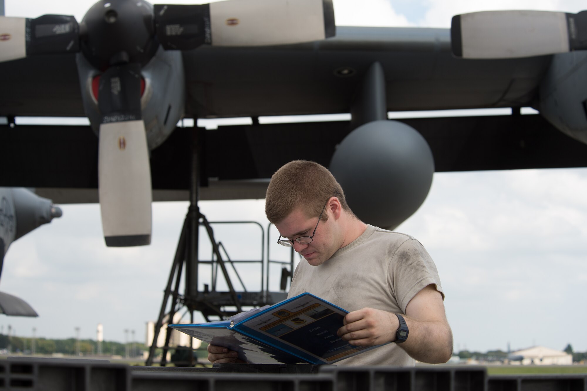 Senior Airman Jonathan Whiting, 374th Aircraft Maintenance Squadron crew chief, checks a manual before maintaining a C-130 Hercules at Yokota Air Base, Japan, Oct. 7, 2013. Airmen are performing a number of exercise tasks as Yokota conducts a Readiness Week. (U.S. Air Force photo by Osakabe Yasuo/Released)