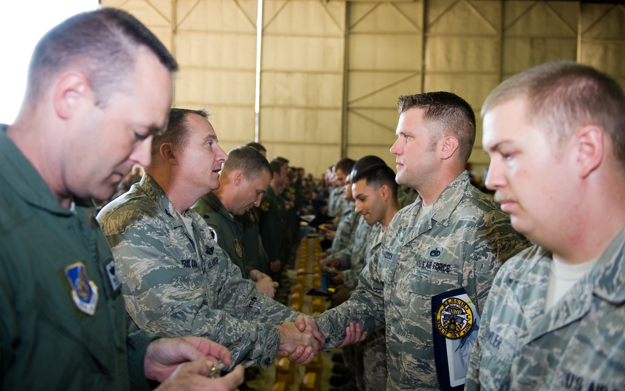 Pilots present their crew chiefs with a coin and certificate during the 2013 Dedicated Crew Chief Ceremony at Kunsan Air Base, Republic of Korea, Oct. 4, 2013. All 8th Fighter Wing F-16 Fighting Falcons on base are assigned a dedicated crew chief to ensure the aircrafts ability to complete its mission. Forty-four maintainers were entrusted with F-16s during the ceremony. (U.S. Air Force photo by Senior Airman Armando A. Schwier-Morales/Released)
