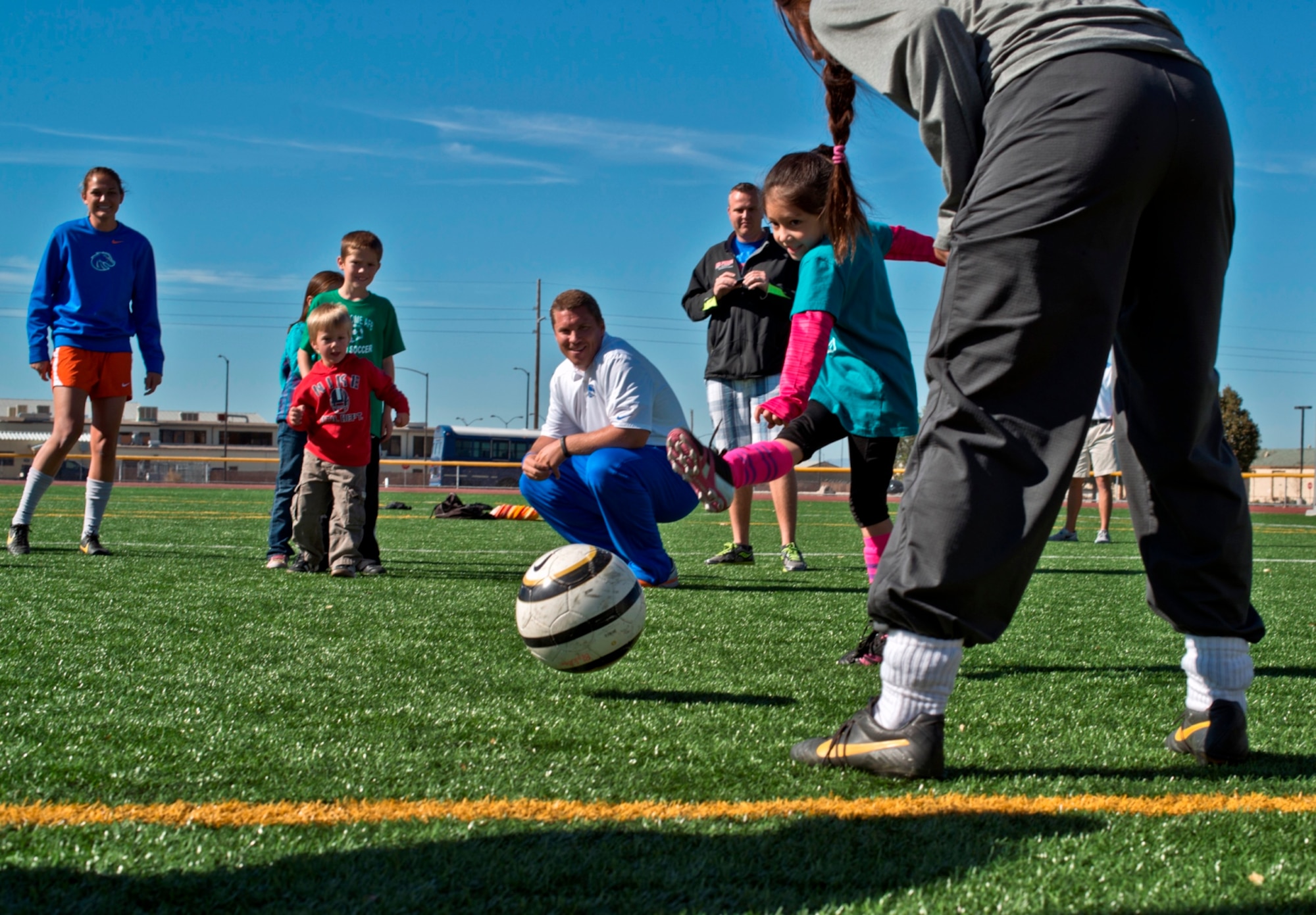 Sporting a ‘Kiss my cleats’ shirt, six-year-old Iris Hartzell, daughter of Maggie and Air Force Staff Sgt. Brendan Hartzell, 366th Communications Squadron, takes a shot at goal at Mountain Home Air Force Base, Idaho, Oct. 5, 2013. The keeper was one of fourteen Boise State University ladies soccer players who visited base as part of their Military Appreciation Day. (U.S. Air Force photo by Master Sgt. Kevin Wallace/RELEASED)