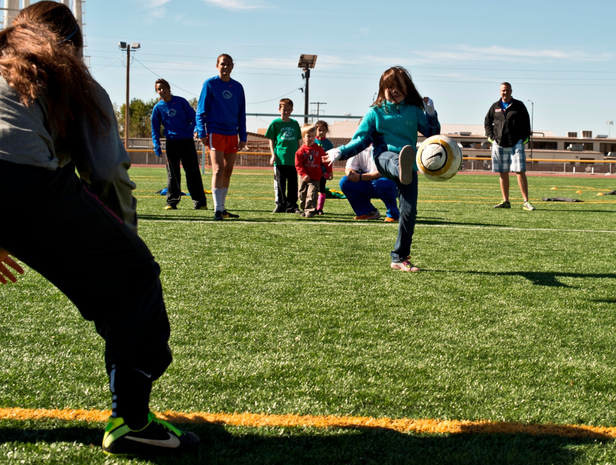 Eight-year-old Natalie Carlsness, daughter of Tech. Sgt. Tim Carlsness, 366th Operations Support Squadron, takes a shot at goal at Mountain Home Air Force Base, Idaho, Oct. 5, 2013. The keeper was one of fourteen Boise State University ladies soccer players who visited base as part of their Military Appreciation Day. (U.S. Air Force photo by Master Sgt. Kevin Wallace/RELEASED)
