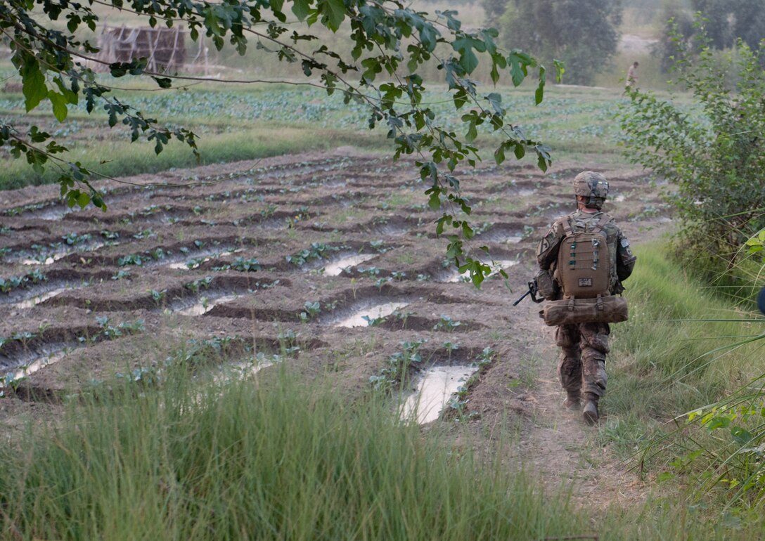 U.S. Army Spc. Cesar Rodriguez skirts a freshly irrigated field during an afternoon reconnaissance patrol near Forward Operating Base Fenty in Afghanistan's Nangarhar province, Sept. 29, 2013. Rodriquez is a medic assigned to the 1st Cavalry Division's 4th Squadron, 9th Cavalry Regiment, 2nd Armored Brigade Combat Team.