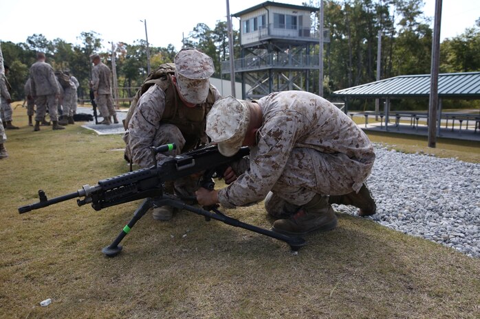 Marines with 2nd Marine Logistics Group attach an M240B medium machine gun to a tripod stand prior to the live-fire portion of the Battle Skills Training School machine gunner course aboard Camp Lejeune, N.C., Oct. 4, 2013. The service members received in-depth training with M240B medium machine guns, MK19 grenade launchers and M2 Browning .50-caliber machine guns.