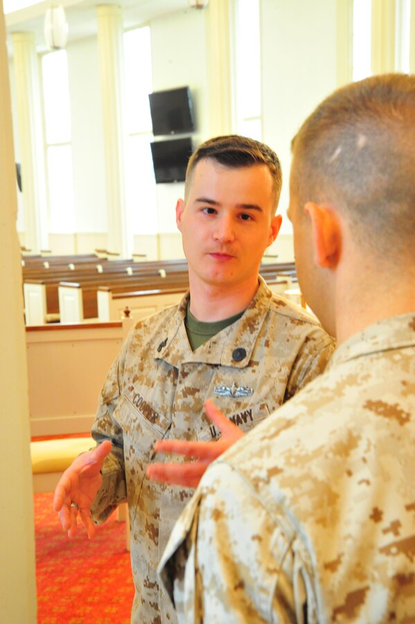Navy Petty Officer 1st Class Jason Cooper, religious program specialist, gives Navy Petty Officer 2nd Class Alexander Farmer a history lesson while preparing mass at the Marine Corps Memorial Chapel on Oct. 8, 2013. Cooper was selected as the Headquarters Marine Corps National Capital Region Senior Sailor of the Quarter.