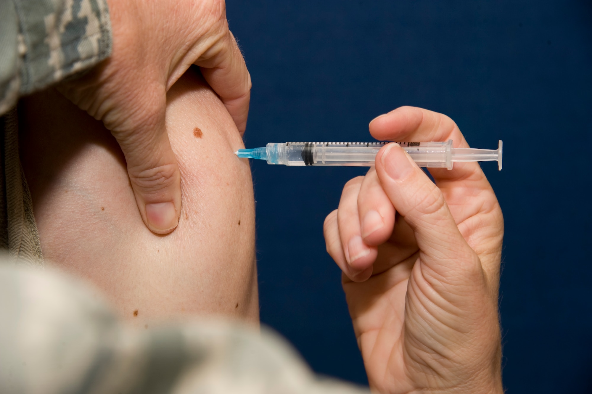 A flu vaccine is administered to an Airman at Transit Center at Manas, Kyrgyzstan, Oct. 2, 2013. The 376th Expeditionary Medical Group has taken steps to keep Transit Center at Manas service members healthy by administering flu vaccinations near the start of flu season. The flu season starts in late October and can continue through March, usually peaking in January or February. (U.S. Air Force photo/Staff Sgt. Krystie Martinez)