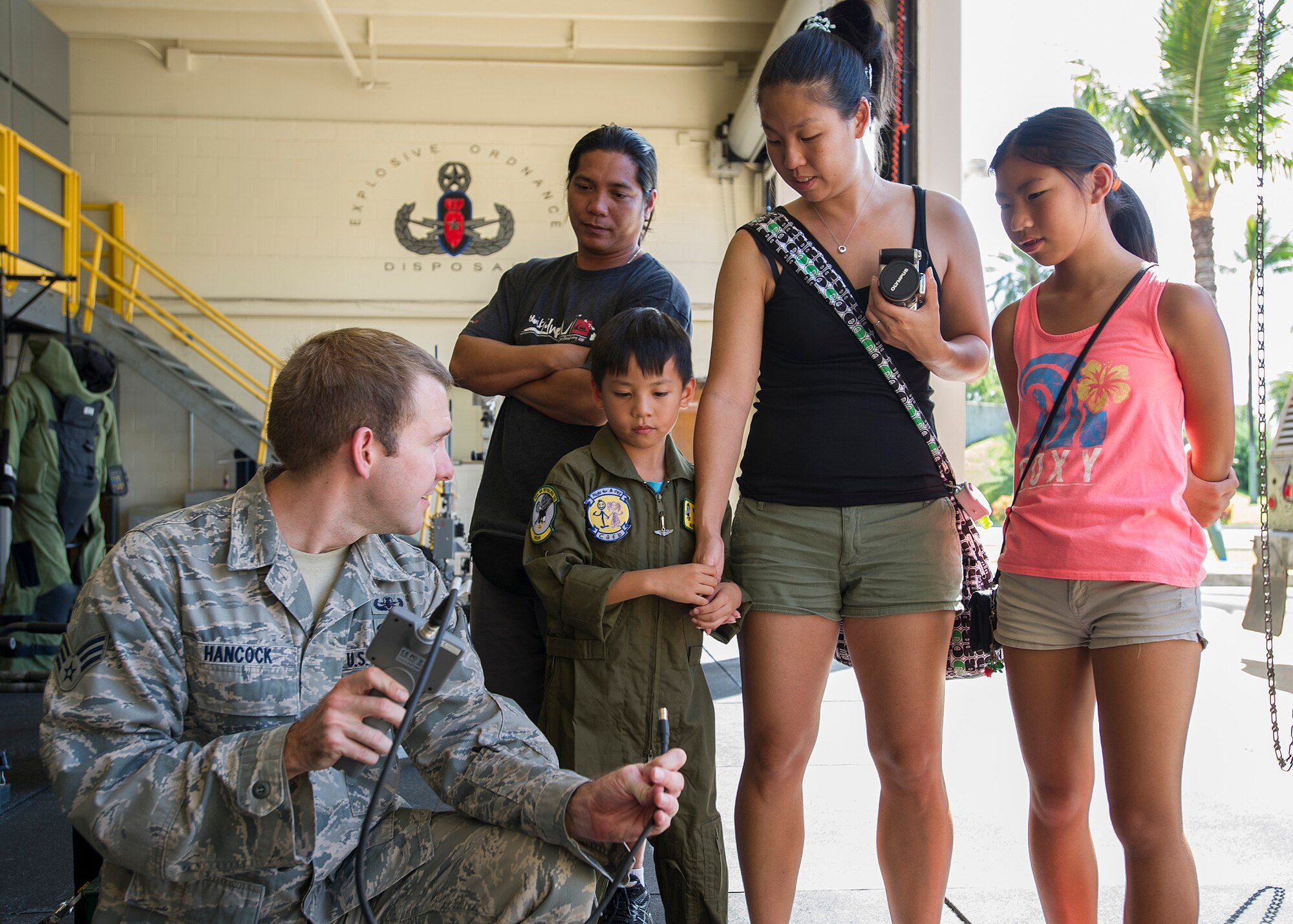 Senior Airman Ben Hancock, 647th Civil Engineer Squadron munitions journeyman, left, demonstrates how to use a microscopic probe to Kodey Deuz, a child battling aortic stenosis, aortic insufficiency and mitral regurgitation, center, and his family as part of the Pilot for a Day program at Joint Base Pearl Harbor-Hickam, Hawaii, Oct. 4, 2013. Kodey was joined on base by his mother, father, and sister to participate in the Pilot For a Day program. (U.S. Air Force photo/Tech. Sgt. Jerome S. Tayborn)