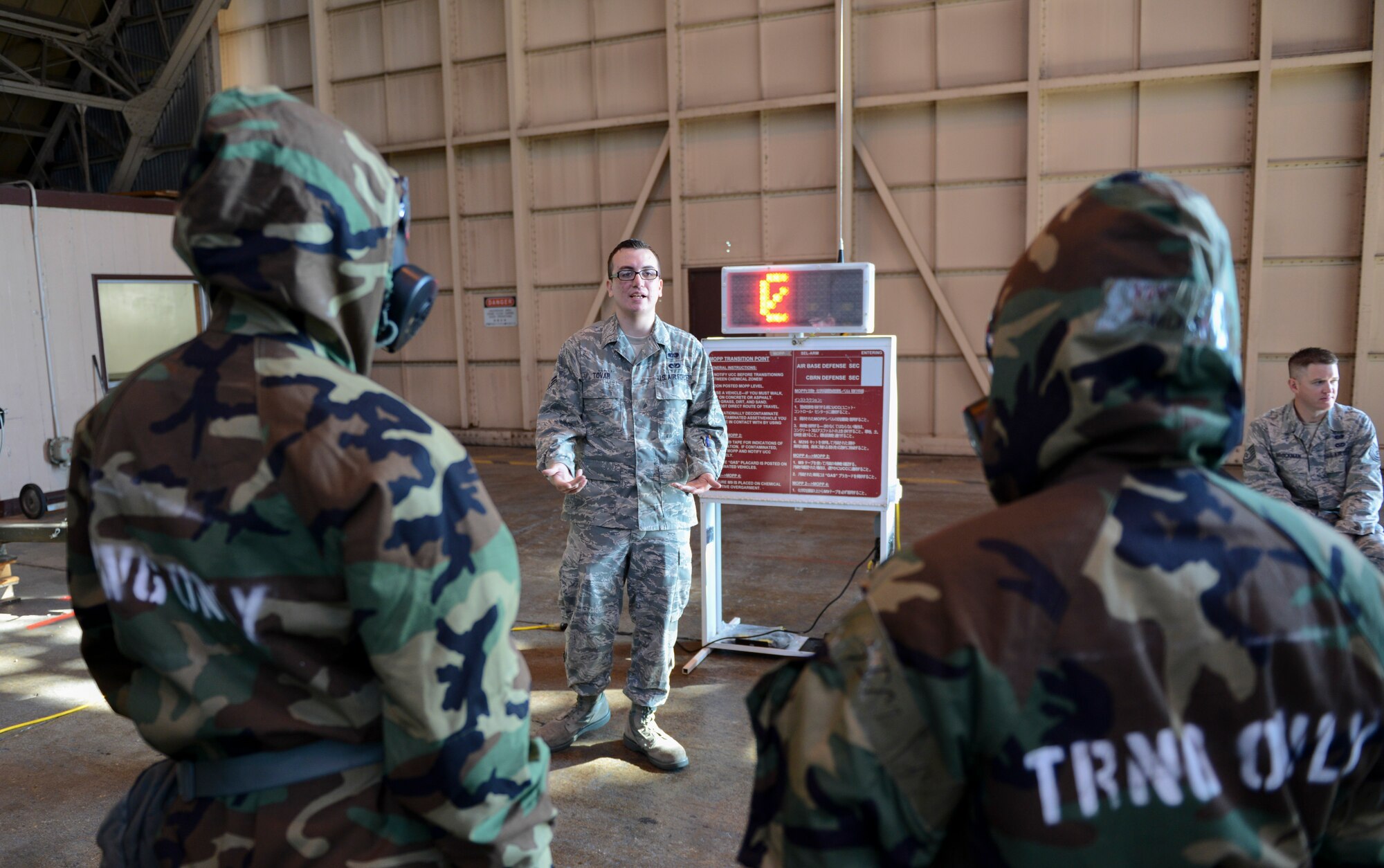 Airman 1st Class Carlos Tovar, 374th Civil Engineer Squadron, explains to Airmen the correct way to cross a mission oriented protective posture zone transition point during the ability to survive and operate rodeo at Yokota Air Base, Japan, Oct. 8, 2013. The number zero represents the MOPP level the Airmen would be walking into on the other side of the sign. (U.S. Air Force photo by Senior Airman Michael Washburn/Released) 