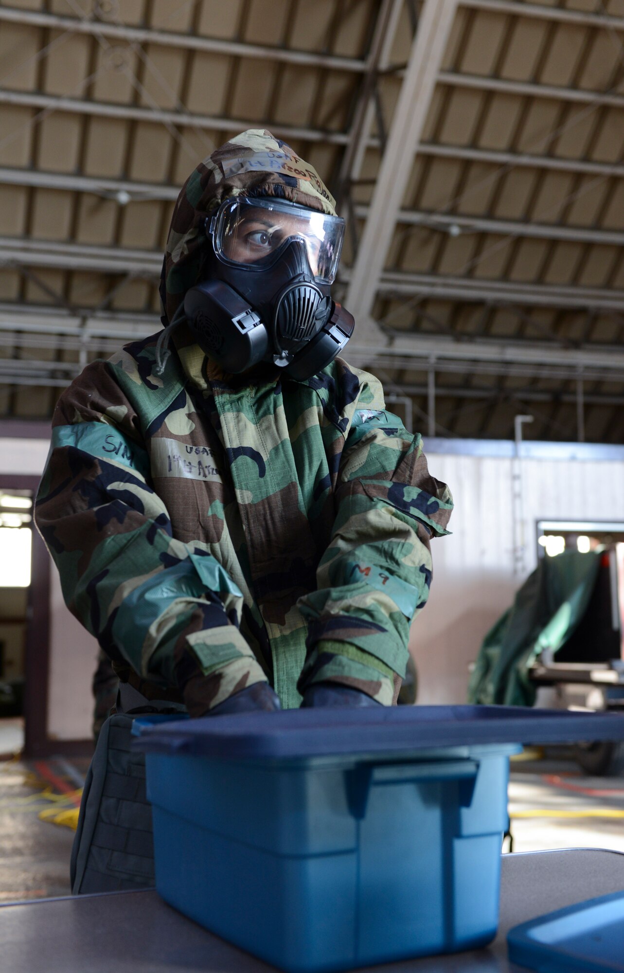 1st Lt. Rajani Arzoo, 374th Airlift Wing Legal Office, simulates rinsing her gloves in decontamination solution during the ability to survive and operate rodeo at Yokota Air Base, Japan, Oct. 8, 2013. Airmen went through all the steps necessary to fully decontaminate themselves following a chemical exposure. (U.S. Air Force photo by Senior Airman Michael Washburn/Released)