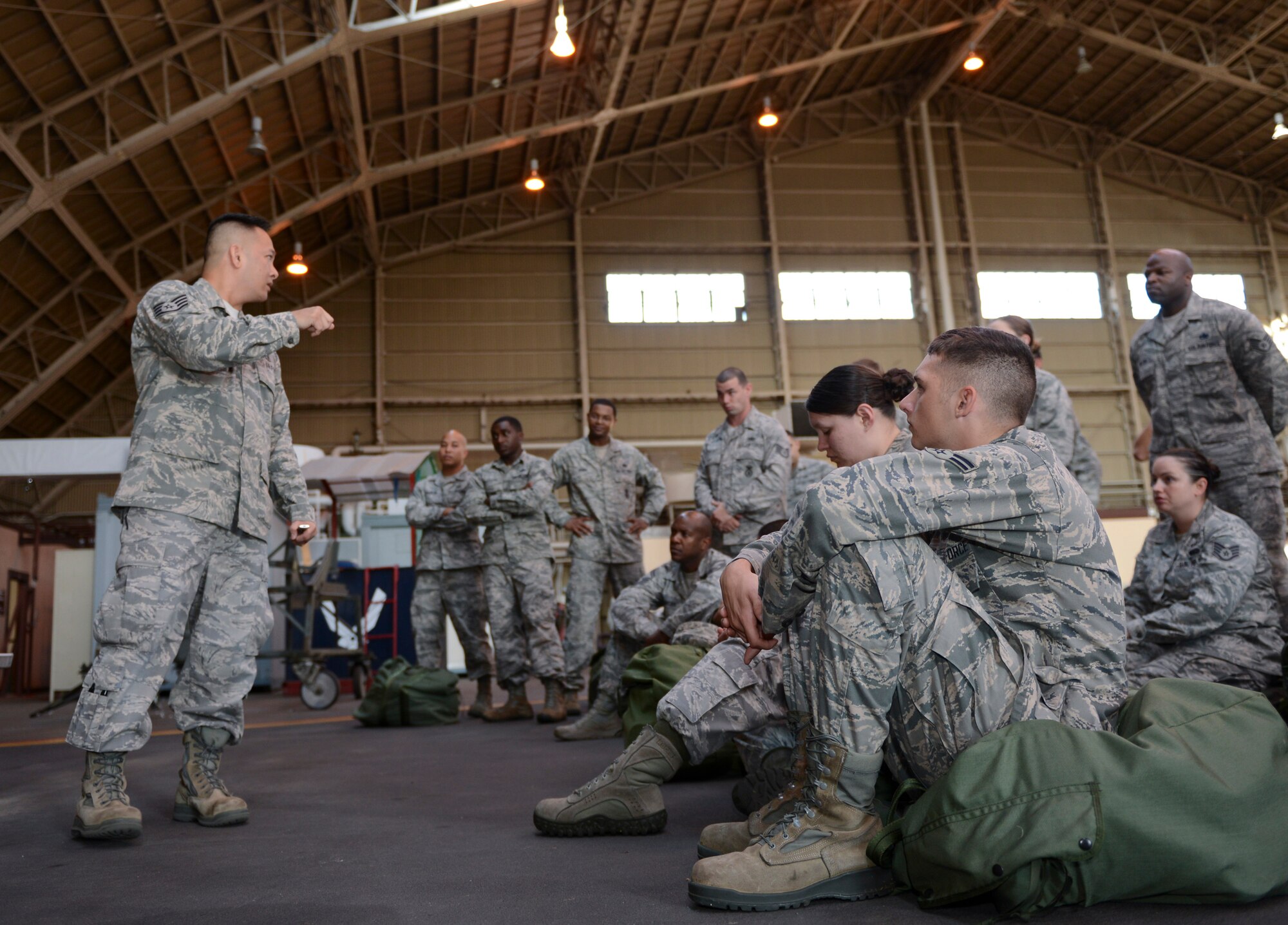 Staff Sgt. Don Flores, 374th Medical Group, briefs a group of Airmen on proper Self Aid Buddy Care techniques and procedures during the ability to survive and operate rodeo at Yokota Air Base, Japan, Oct. 8, 2013. Topics included how to apply a tourniquet, combat gauze application, how to properly carry a litter and nasopharyngeal airway implementation. (U.S. Air Force photo by Senior Airman Michael Washburn/Released)