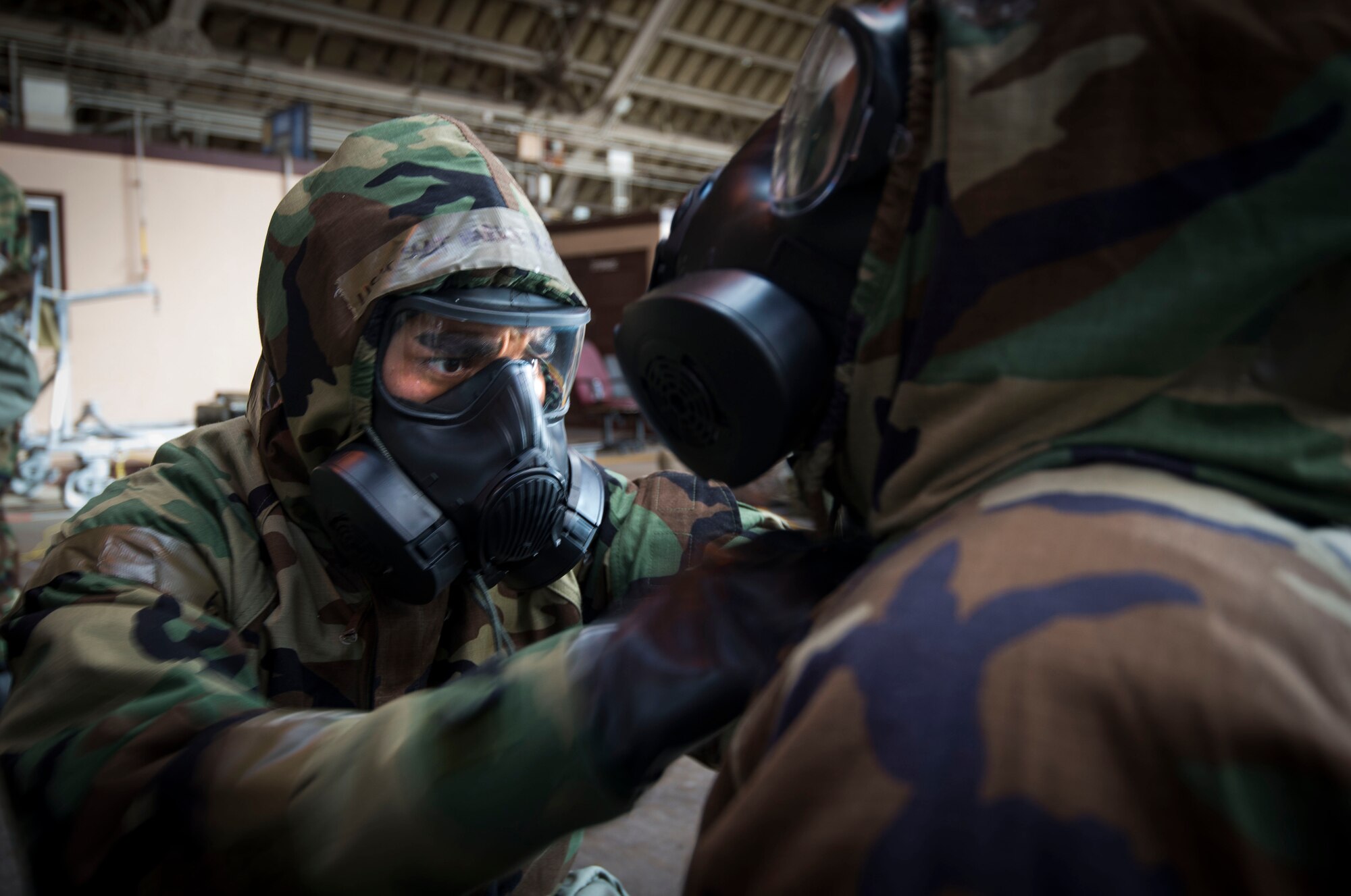 Master Sgt. Don Salvio, 374th Force Support Squadron, performs a buddy check during ability to survive and operate (ATSO) training Oct. 9, 2013 at Yokota Air Base, Japan. Donning chemical gear was one of seven stations where Airmen were reacquanted with basic contingency skills. (U.S. Air Force photo by Staff Sgt. Chad C. Strohmeyer/Released)
