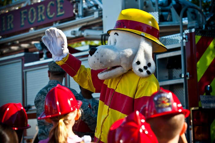 Sparky the Fire Dog greets children at the child development center Oct. 8, 2013, at Nellis Air Force Base, Nev. The 99th Civil Engineer Squadron firefighters are visiting various locations around Nellis during Fire Prevention Week to spread the word that more fires start in the kitchen than in any other part of the home.  (U.S. Air Force photo/Senior Airman Brett Clashman)