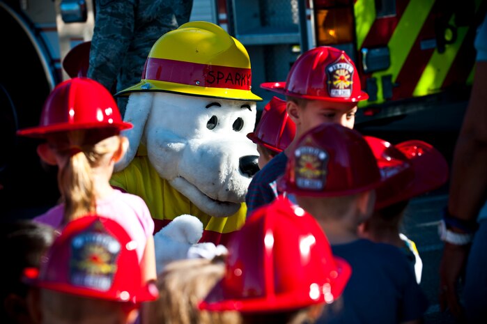 Sparky the Fire Dog greets children at the child development center Oct. 8, 2013, at Nellis Air Force Base, Nev. The 99th Civil Engineer Squadron firefighters are visiting different parts of Nellis AFB to educate the base populace on how to prevent kitchen fires during Fire Prevention Week. (U.S. Air Force photo/Senior Airman Brett Clashman)