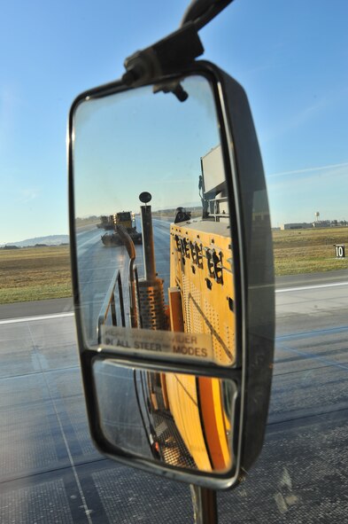 Snow brooms scrub the runway to enhance the chemical reaction during the flightline rubber removal process Oct. 4, 2013. The 92nd Civil Engineer Squadron snow barn team gathered with the 92nd CES fire department to conduct rubber removal on more than 4,000 feet of Fairchild’s flightline. (U.S. Air Force photo/Staff Sgt. Veronica Montes) 

