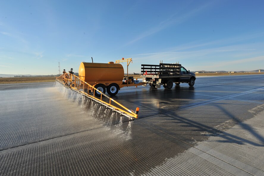 A de-icing truck sprays water on the runway to enhance the chemical reaction during the flightline rubber removal process, Oct. 4, 2013, at Fairchild Air Force Base, Wash. The 92nd Civil Engineer Squadron snow barn team gathered with the 92nd CES fire department to conduct rubber removal on more than 4,000 feet of Fairchild’s flightline. (U.S. Air Force photo/Staff Sgt. Veronica Montes) 

