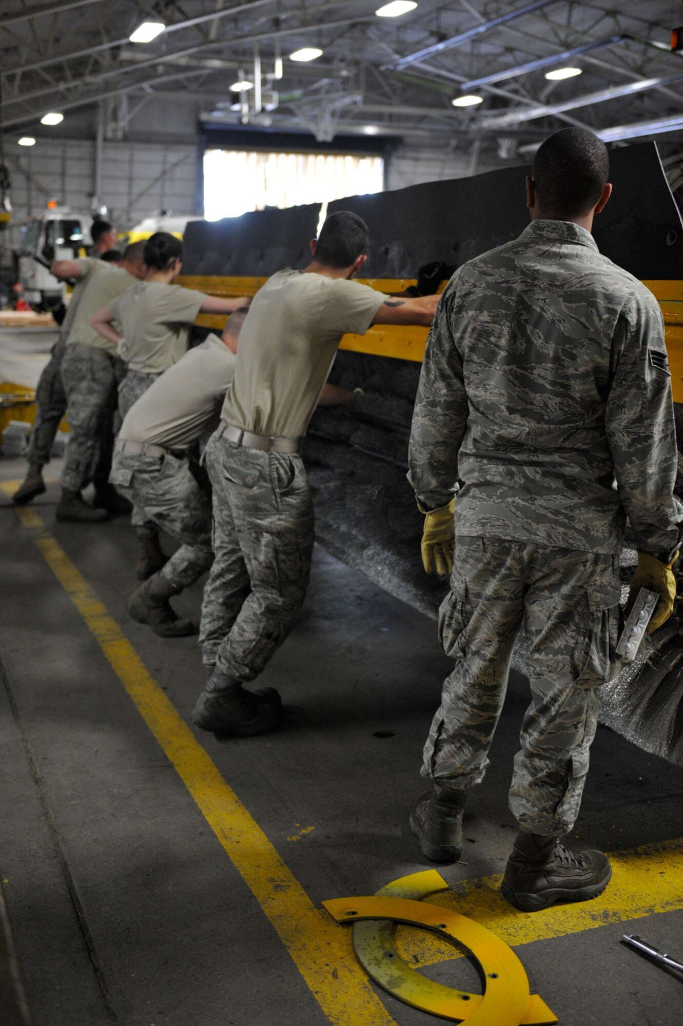 Several Airmen inspect an NB front mount broom machine during Snow School training on Joint Base Elmendorf-Richardson, Oct. 4. Selected Airmen attended an in depth three week course to learn about a variety of heave equipment they will use during the winter months for snow removal. (U.S. Air Force photo/Airman 1st Class Tammie Ramsouer)