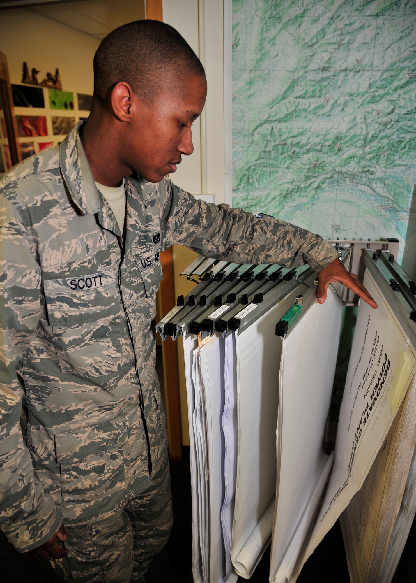 Airman 1st Class Lakeye Scott, 354th Civil Engineer Squadron GeoBase flight engineering assistant, sorts and organizes as-built floor plans Oct. 3, 2013, Eielson Air Force Base, Alaska. Each year the Iceman GeoBase team makes hundreds of custom maps for projects around base. (U.S. Air Force photo by Senior Airman Ashley Nicole Taylor/Released)
