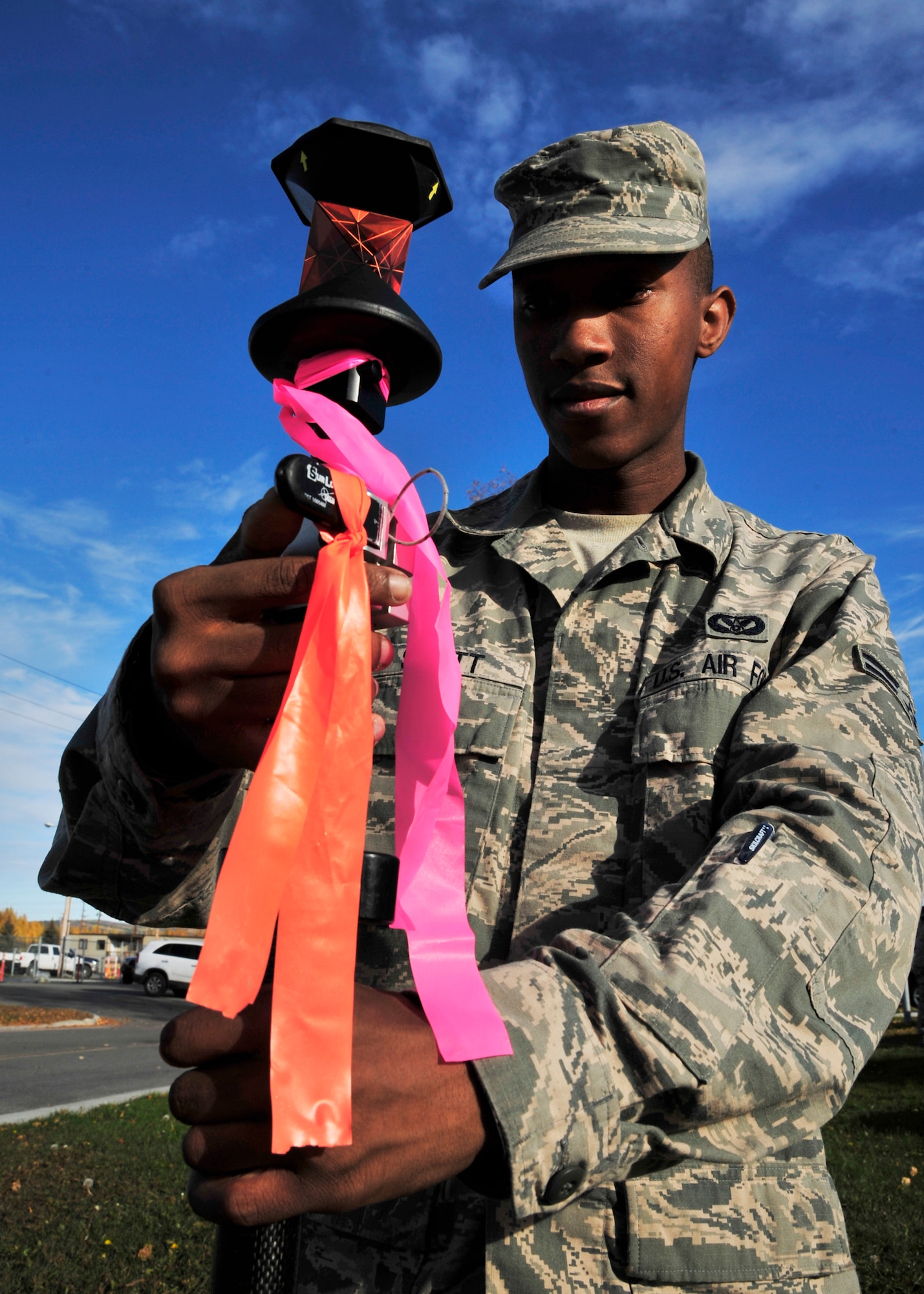 Airman 1st Class Lakeye Scott, 354th Civil Engineer Squadron GeoBase flight engineering assistant, levels a survey rod Oct. 3, 2013, Eielson Air Force Base, Alaska. The purpose of the prism on the survey rod is to get the correct elevation for a point. (U.S. Air Force photo by Senior Airman Ashley Nicole Taylor/Released)