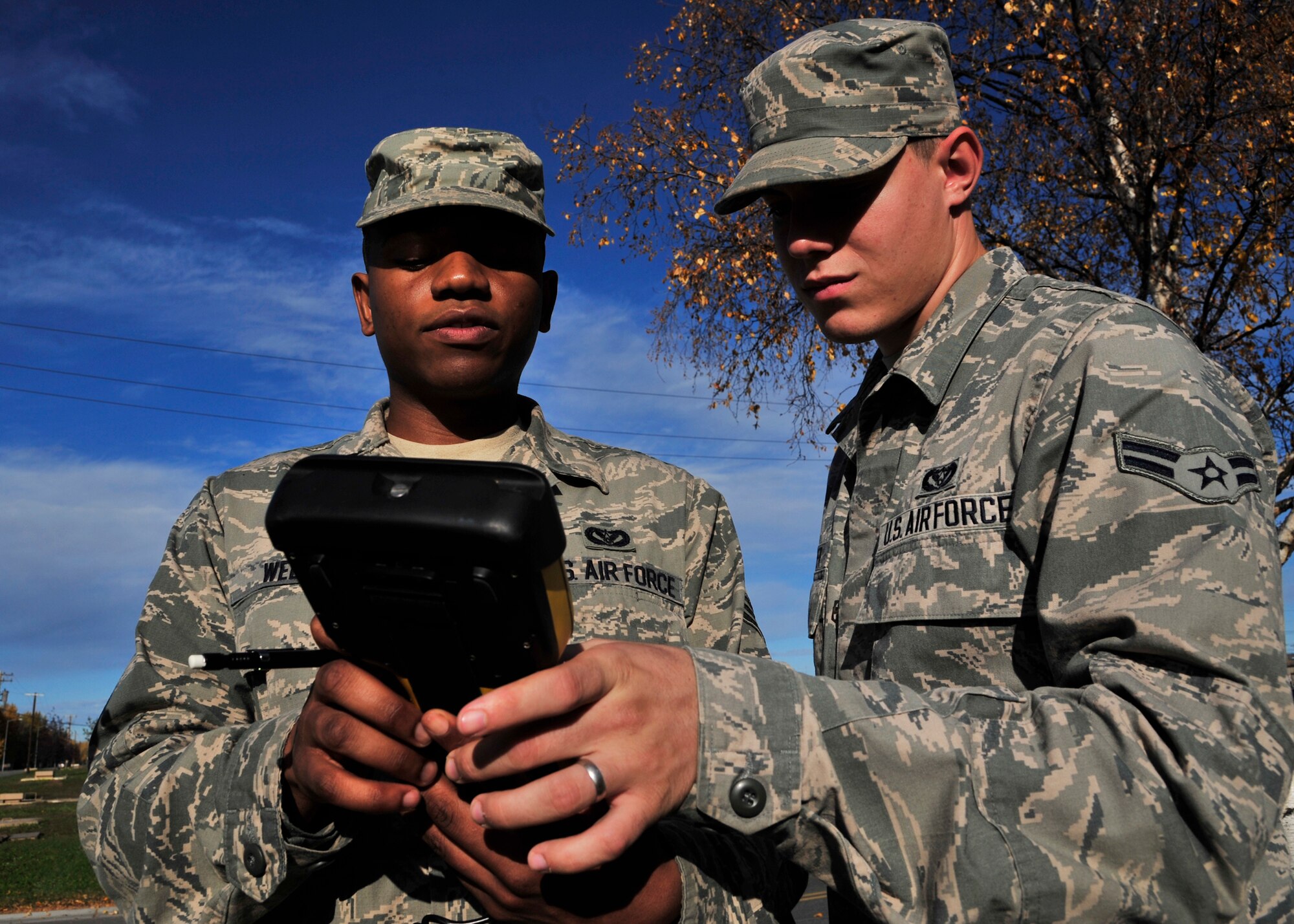 Senior Airman Daniel Wells and Airman 1st Class William Harper, 354th Civil Engineer Squadron GeoBase flight engineering assistants, set up a survey station Oct. 3, 2013, Eielson Air Force Base, Alaska. Eielson GeoBase is committed to serving many missions that require mapping technology, surveying, site planning or situational awareness. (U.S. Air Force photo by Senior Airman Ashley Nicole Taylor/Released)