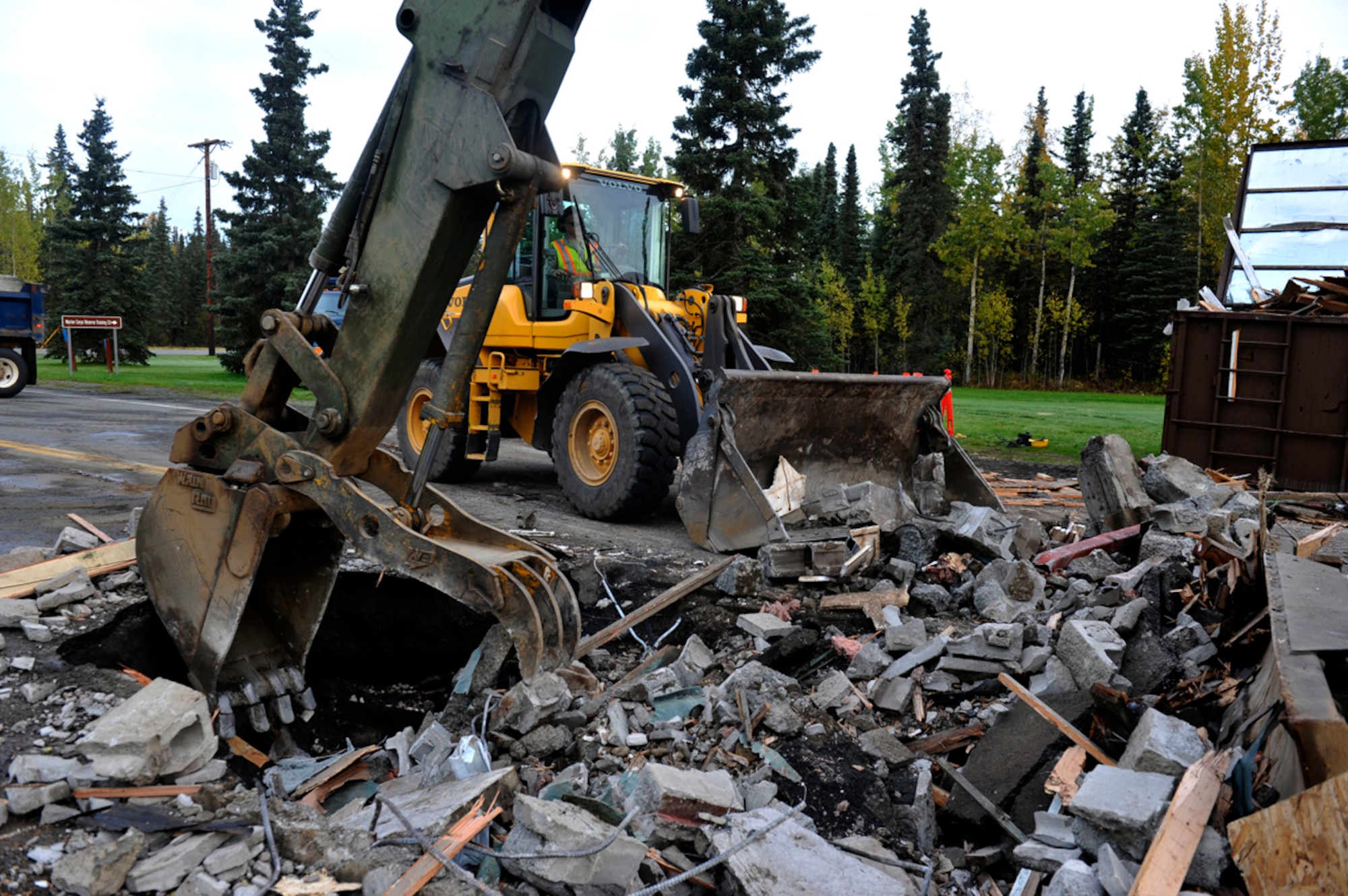 Dirt Boyz' from the 773rd Civil Engineer Group demolish Building 45000 on Joint Base Elmendorf-Richardson, Sept. 28.  The guard shack was one of the last buildings separating the former Elmendorf Air Force Base and Fort Richardson after the 2010 merger into a joint base. (U.S. Air Force photo/Airman 1st Class Tammie Ramsouer)