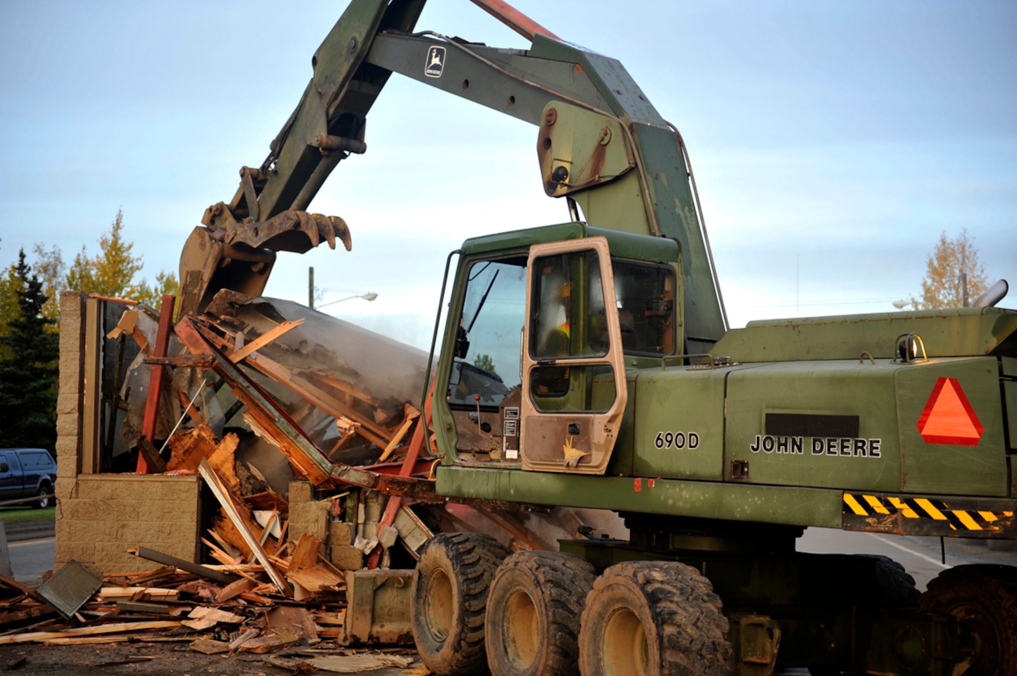 Dirt Boyz' from the 773rd Civil Engineer Group demolish Building 45000 on Joint Base Elmendorf-Richardson, Sept. 28.  The guard shack was one of the last buildings separating the former Elmendorf Air Force Base and Fort Richardson after the 2010 merger into a joint base. (U.S. Air Force photo/Airman 1st Class Tammie Ramsouer)