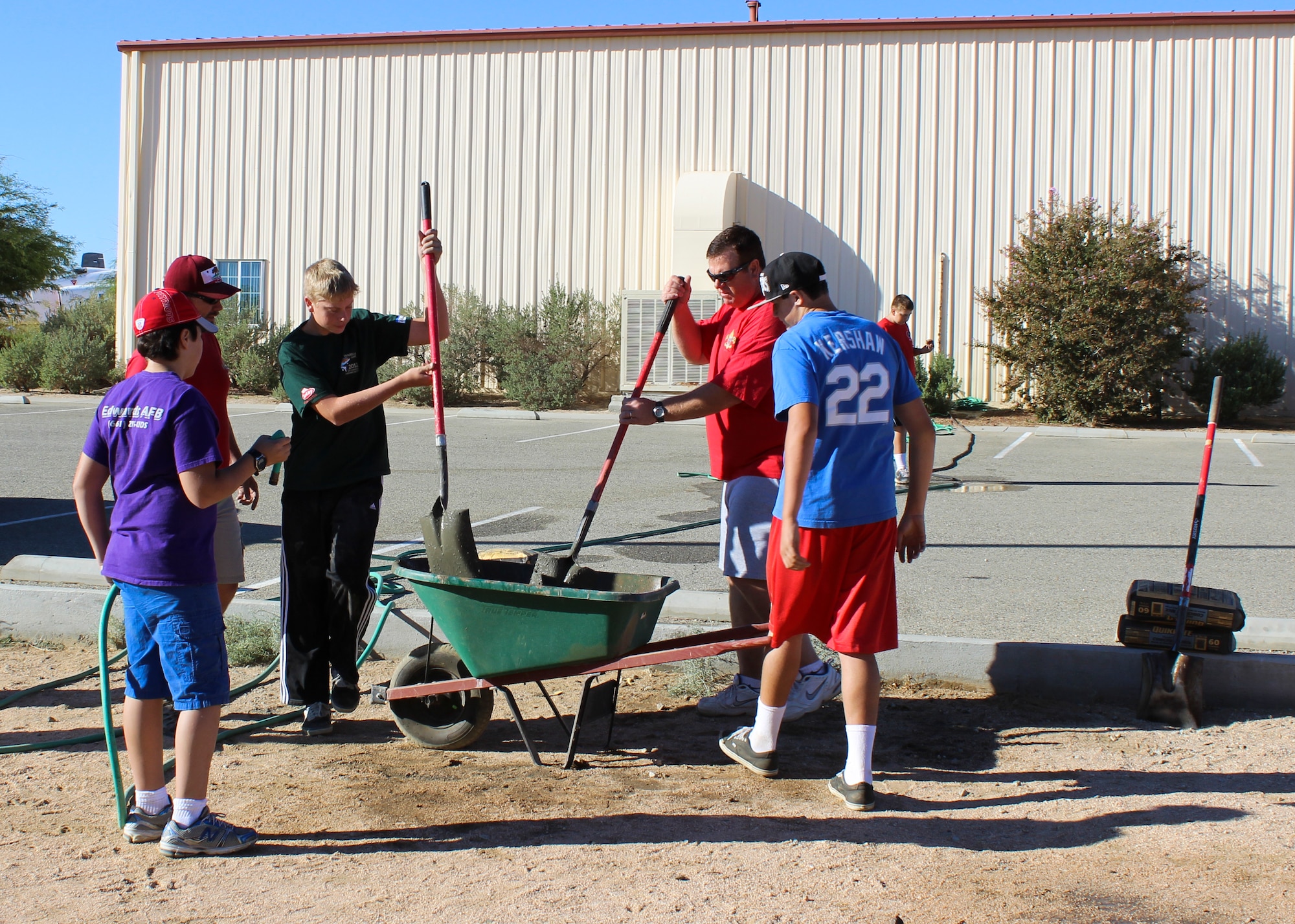 A group of volunteers hand-mixes concrete to create slabs for the T-38 to sit on. (Courtesy photo)