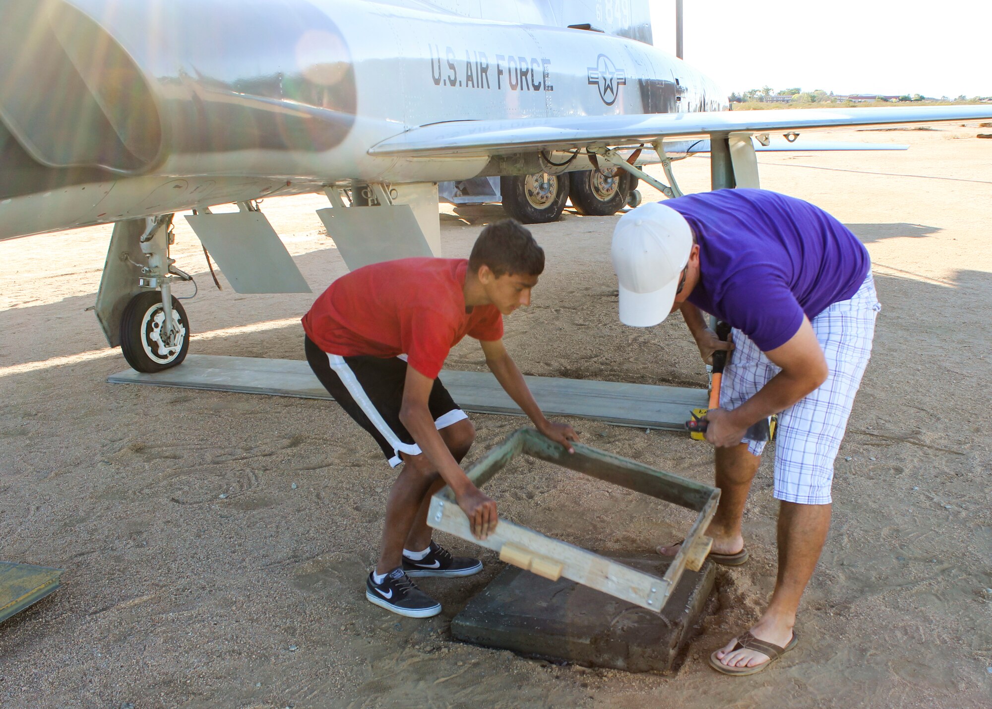 Jacob Huck (left) and Jason Garrett (right) prepare the cement slabs to support the T-38 landing gear. (Courtesy photo)
