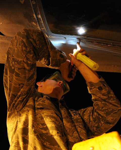 Airman 1st Class Alexander Prevost, 92nd Aircraft Maintenance Squadron crew chief, installs the boom sighting window of a KC-135 Stratotanker at Fairchild Air Force Base, Wash., Sept. 25, 2013. Cleaning the boom sighting window is part of the preflight inspection, which is required prior to flight. (U.S. Air Force photo/Airman 1st Class Janelle Patiño)