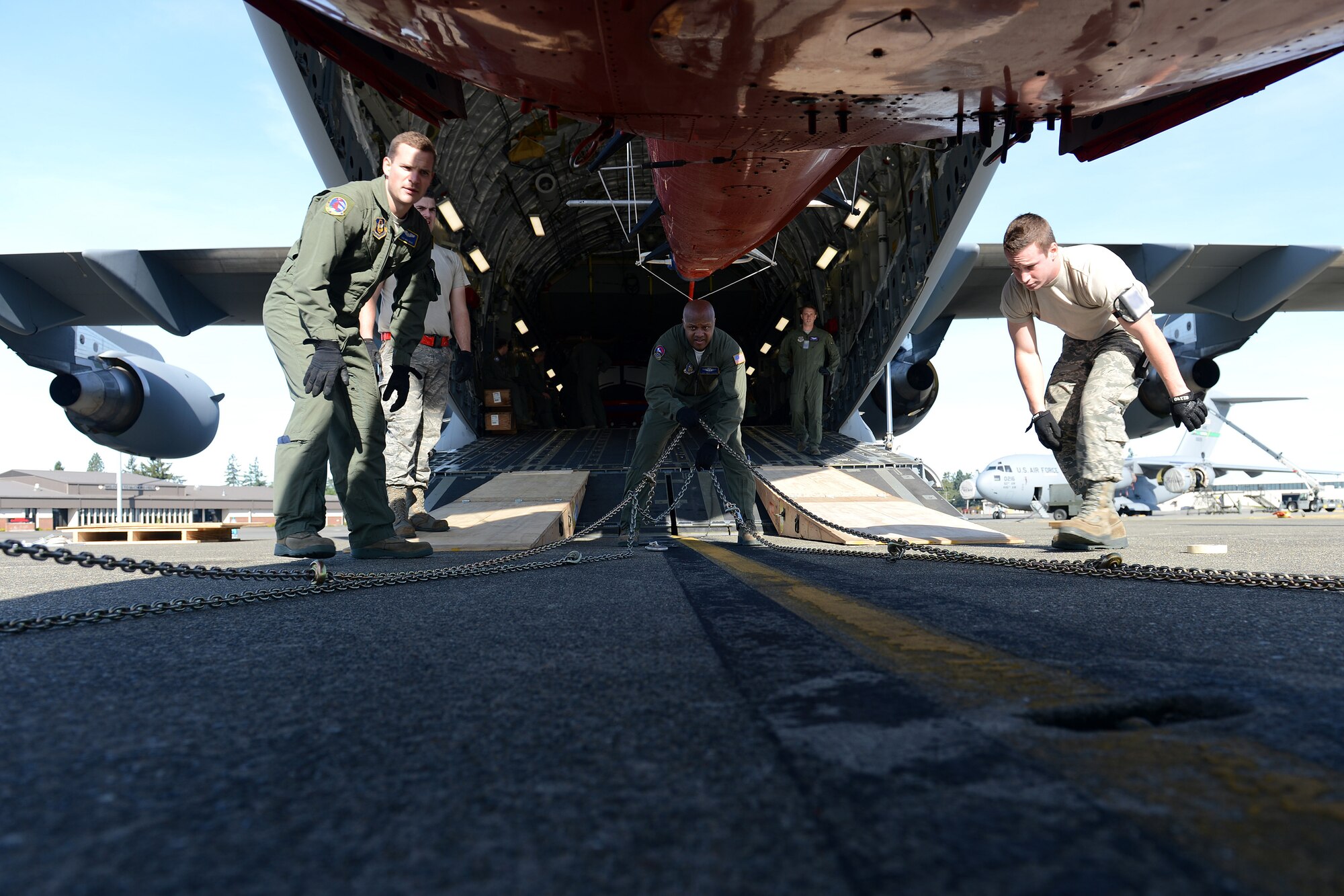 Loadmasters from the 62nd and 446th Airlift Wings attach chains to an AS-350 helicopter, Oct. 5, 2013, at Joint Base Lewis-McChord, Wash., prior to loading it onto a C-17 Globemaster III aircraft in support of Operation Deep Freeze. As part of the 304th Expeditionary Airlift Squadron, 35 McChord Airmen departed on the first of two scheduled rotations in support of the 2013-2014 Operation Deep Freeze main season. ODF missions will run through Antarctica’s summer months, which are October through February. (U.S. Air Force Photo/Airman 1st Class Jacob Jimenez)