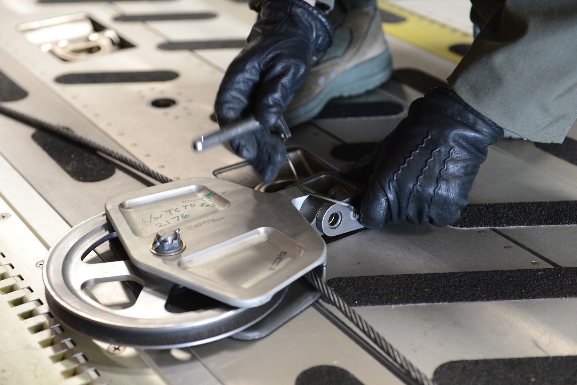 Tech. Sgt. Jeff Austin, 10th Airlift Squadron evaluator loadmaster, affixes a pulley to an aircraft cargo winch cable in a C-17 Globemaster III aircraft, Oct. 5, 2013, at Joint Base Lewis-McChord, Wash., prior to loading a helicopter onto the aircraft in preparation for deployment. A total of 35 McChord Airmen deployed to Christchurch, New Zealand, as part of the 304th Expeditionary Airlift Squadron, where they will provide airlift into and out of McMurdo Station, Antarctica, in support of Operation Deep Freeze. (U.S. Air Force Photo/Airman 1st Class Jacob Jimenez)