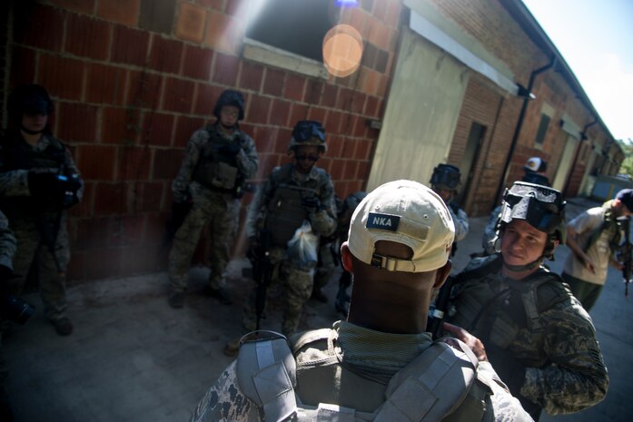 Airmen from 1st Combat Camera Squadron listen to Tech. Sgt. Denoris Mickle, 1st CTCS photo element lead, tell them how they performed doing the scenario of the exercise Oct. 4, 2013, at Joint Base Charleston - Weapons Station, S.C. Combat Camera Airmen learned how to document outside the wire operations by patrolling through four villages and engaging hostile forces in simulated training. The exercise was geared to familiarize and test the Airmen on their ability to operate outside the wire as combat documentation specialists. (U.S. Air Force photo/Tech. Sgt. Rasheen Douglas)


