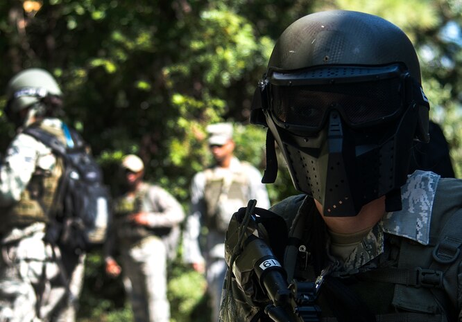 Senior Airman Sandra Welch, 1st Combat Camera Squadron combat photographer, provides security while her team engages hostile forces during an exercise Oct. 4, 2013, at the Joint Base Charleston-Weapons Station, S.C. Airmen from the 1st CTCS trained on how to document outside the wire operations by patrolling through four villages and engaging hostile forces in simulated training. The exercise was geared to familiarize and test the Airmen on their ability to operate outside the wire as combat documentation specialists. (U.S. Air Force photo/Tech. Sgt. Rasheen Douglas)