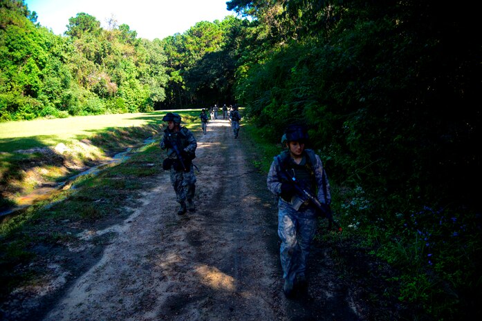 1st Combat Camera Squadron Airmen walk through the woods during a simulated patrol Oct. 4, 2013, at Joint Base Charleston - Weapons Station. Airmen from the 1st CTCS trained on how to document outside the wire operations by patrolling through four villages and engaging hostile forces in simulated training. The exercise was geared to familiarize and test the Airmen on their ability to operate outside the wire as combat documentation specialists. (U.S. Air Force photo/Tech. Sgt. Rasheen Douglas)