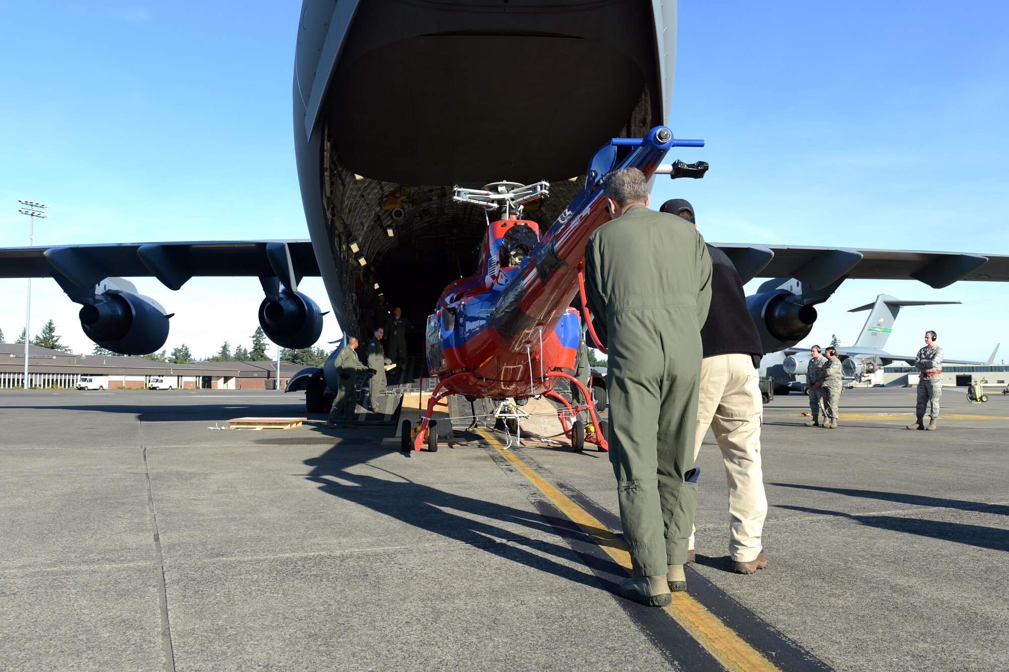 Chief Master Sgt. Jim Masura, 304th Expeditionary Airlift Squadron operations superintendent, loads an AS-350 helicopter onto a C-17 Globemaster III aircraft, Oct. 5, 2013, at Joint Base Lewis-McChord, Wash. More than 35 Airmen from McChord Field deployed to Christchurch, New Zealand, as part of the 304th Expeditionary Airlift Squadro, to provide airlift support for the National Science Foundation's mission at McMurdo Station, Antarctica. (U.S. Air Force Photo/Airman 1st Class Jacob Jimenez)