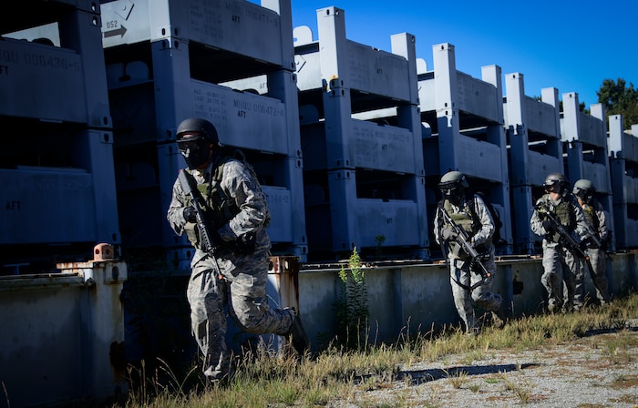 Airmen from the 1st Combat Camera Squadron practice maneuver tactics during a simulated patrol Oct. 4, 2013, on Joint Base Charleston - Weapons Station, S.C. Combat Camera Airmen trained on how to document outside the wire operations by patrolling through four villages and engaging hostile forces in simulated training. The exercise was geared to familiarize and test the Airmen on their ability to operate outside the wire as combat documentation specialists. (U.S. Air Force photo/Tech. Sgt. Rasheen Douglas)
