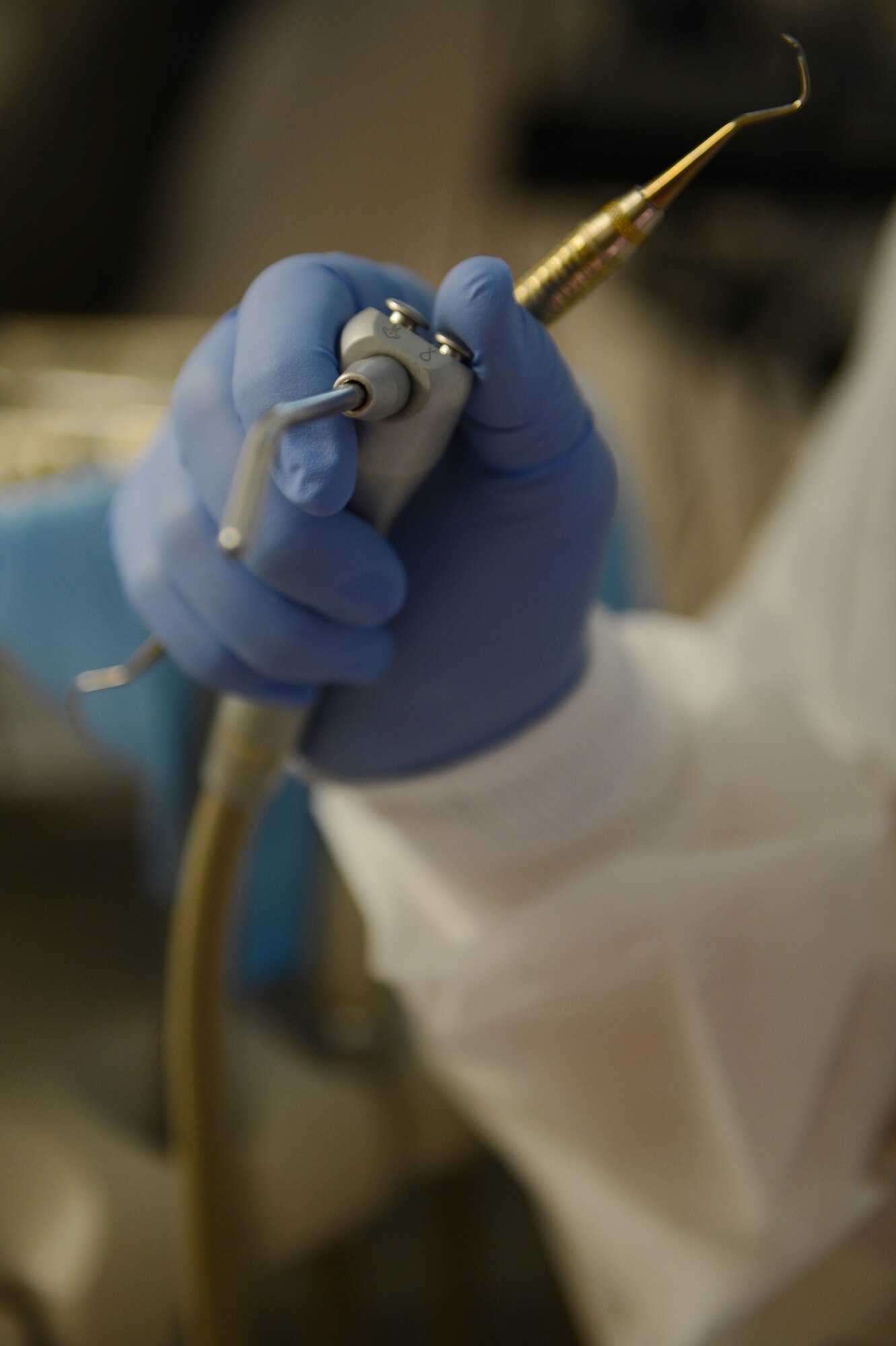 Staff Sgt. Tonya Collett, 20th Dental Squadron dental technician, grabs a tool to rinse away plaque that has been dislodged from her patient’s teeth and gum line at Shaw Air Force Base, S.C., Sept. 30, 2013. Once the plaque had been cleared away, Collett finished the cleaning by polishing the teeth. (U. S. Air Force photo by Airman 1st Class Krystal M. Jeffers/Released)