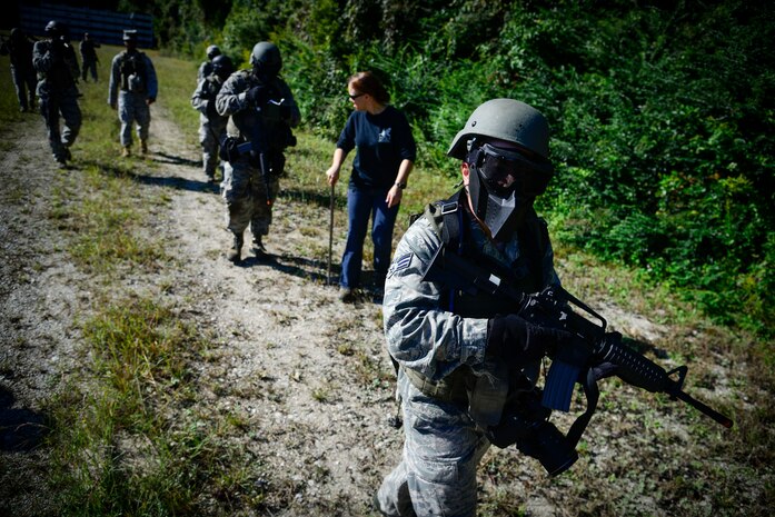 Airmen from the 1st Combat Camera Squadron provide security while on a simulated patrol Oct. 4, 2013, at Joint Base Charleston - Weapons Station, S.C. Airmen from the 1st CTCS trained on how to document outside the wire operations by patrolling through four villages and engaging hostile forces in simulated training. The exercise was geared to familiarize and test the Airmen on their ability to operate outside the wire as combat documentation specialists. (U.S. Air Force photo/Tech. Sgt. Rasheen Douglas