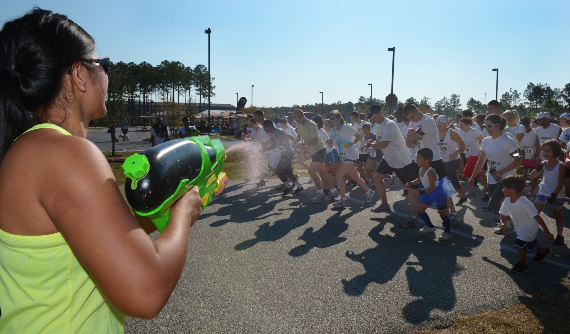 Team Shaw members get a pre-color spray down at the start of the Shut Up and Color Run 5K at Shaw Air Force Base, S.C., Oct. 5, 2013. The 20th Force Support Squadron held Shaw's first Shut Up and Color Run, in which the participants were doused in colored powder. (U.S. Air Force photo by Senior Airman Tabatha Zarrella/Released) 
