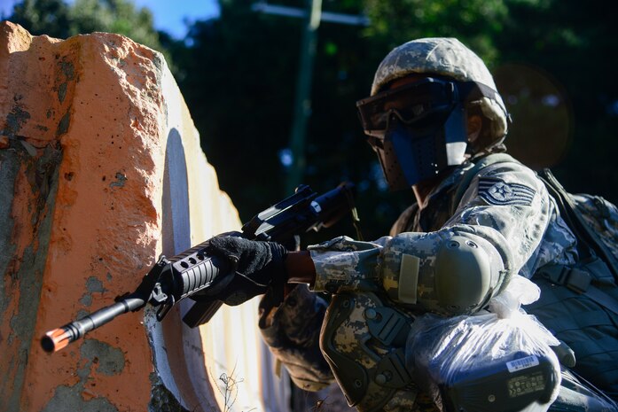 Tech. Sgt. Lakisha Croley, 1st Combat Camera Squadron alternate non-commissioned officer-in-charge of photography training, provides security for her team to get into position during an exercise Oct. 4, 2013, at Joint Base Charleston - Weapons Station, S.C. Airmen from the 1st CTCS trained on how to document outside the wire operations by patrolling through four villages and engaging hostile forces in simulated training. The exercise was geared to familiarize and test the Airmen on their ability to operate outside the wire as combat documentation specialists. (U.S. Air Force photo/Tech. Sgt. Rasheen Douglas)