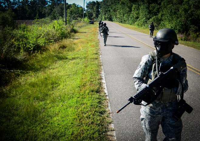 Airmen from the 1st Combat Camera Squadron walk during a simulated patrol on Oct. 4, 2013, at Joint Base Charleston - Weapons Station, S.C. Airmen from the 1st CTCS trained on how to document outside the wire operations by patrolling through four villages and engaging hostile forces in simulated training. The exercise was designed to test the Airmen physically and mentally. (U.S. Air Force photo/Tech. Sgt. Rasheen Douglas)