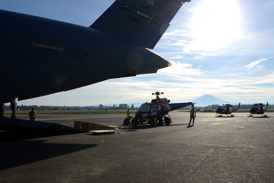 Loadmasters from 62nd and 446th Airlift Wings prep an AS-350 helicopter, Oct. 5, 2013, for transport on a C-17 Globemaster III, at Joint Base Lewis-McChord, Wash. The helicopters were bound for Christchurch, New Zealand, where they will be used in support of the 2013-2014 Operation Deep Freeze season.  (U.S. Air Force Photo/Airman 1st Class Jacob Jimenez)